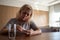 Woman lying at the table, depressed, lonely, sick, despondent, unhappy, suffering, among pills