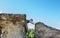 Woman lying on top of a high sandstone rock formation lying over the edge.