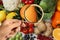 Woman with magnifying glass focusing on orange, closeup. Food control