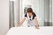 Woman in maid uniform making bed. Portrait of female housecleaner putting on new blankets and clean hotel room, trying