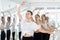 Woman maintaining third position at ballet barre at group rehearsal