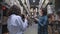 Woman makes clip content with concentrated brunette guy with clipboard standing on high shelves in spacious warehouse