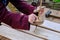 A woman makes holes in a tree with a vintage hand-drawn drill. An ancient way to create holes in the Board using spinning top