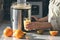 A woman makes orange juice at home in the kitchen with an electric juicer.