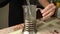 A woman makes tea in a French press, pouring boiling water into it.