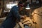 Woman makes a work of wood in the workshop.