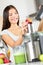 Woman making apple and vegetable juice on juicer