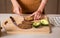 Woman making avocado peanut butter toast for a healthy breakfast