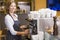 Woman making coffee in restaurant smiling