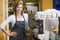 Woman making coffee in restaurant smiling