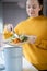 Woman Making Compost From Vegetable Leftovers In Kitchen