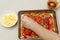 Woman making delicious homemade rectangular pizza in top view