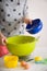 Woman making dough for muffins. Mixing flour, sugar, eggs and other ingredients from colorful bowls. Homemade food, baking at home