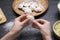 Woman making dumplings (varenyky) at black table, closeup