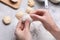 Woman making dumplings (varenyky) at grey table, closeup