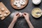 Woman making dumplings (varenyky) with potato at black table, top view