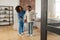 Woman making first steps with crutches standing near private nurse