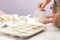 Woman making hand made soap bar with lavender flowers at table