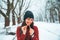 Woman making heart symbol with christmas candy outside in winter snowed park