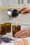 Woman making homemade candle at table in kitchen, closeup