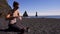 Woman making hot drink on Reynisfjara beach near Vik, Icealnd