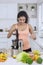 Woman making juice from vegetables and fruits