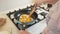 A woman is making an omelette. Preparation of eggs in a frying pan.