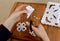 Woman making paper snowflakes at a wooden craft table