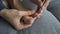 Woman is making pedicure herself removing cuticle and pterygium on toe, closeup.