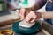 Woman making pottery, hands closeup, blurred background, focus on potters, palms with pottery