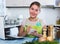 Woman making shopping list at kitchen