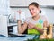 Woman making shopping list at kitchen