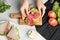 Woman making tasty sandwich with sausage at grey marble table, top view