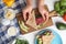 Woman making tasty sandwich with sausage at table, top view