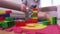 Woman making tower from toy bricks