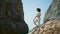 Woman making yoga asana standing rocky beach. African american girl stretching.