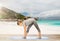 Woman making yoga intense stretch pose on beach