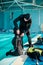 Woman and male divemaster tries on scuba gear