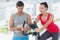 Woman with male instructor working out at spinning class