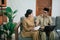 woman and man in civilian uniforms using laptop and workbook while sitting