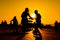 Woman and man couple silhouettes dancing against warm sunset orange sky