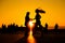 Woman and man couple silhouettes dancing against warm sunset orange sky