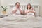 A woman and a man are in doubt after the birth of a newborn baby on the bed. Father and mother with a child boy, thoughtful