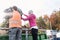 Woman and man giving waste green in container on recycling center