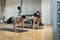 Woman and man in gym perform plank exercise with the help of a personal trainer.