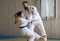 Woman and man judo fighters in sport hall