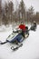 Woman and man managing snowmobile in Ruka of Lapland