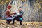 Woman and man petting the dog walking her in a colorful fall setting