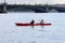 Woman and man in a sea kayak swim on the river in the city center