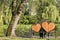 Woman and man are sitting on a bench with two big hearts under